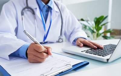 Doctor checking information in computer program before filling medical card